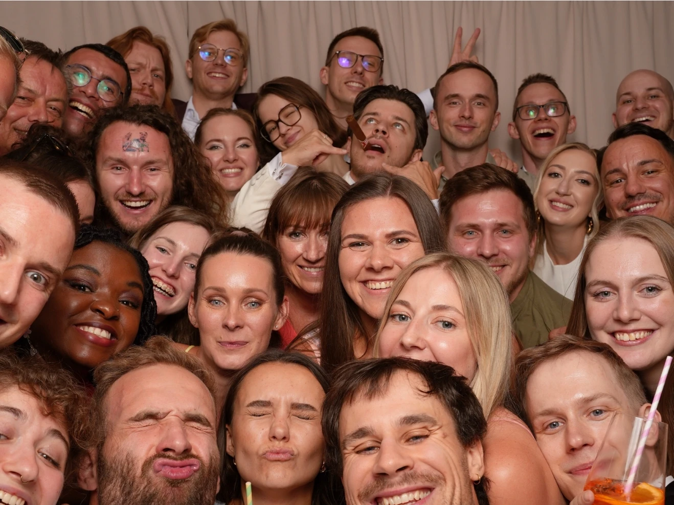 Velká skupinová fotka plná úsměvů z fotokoutku na akci.